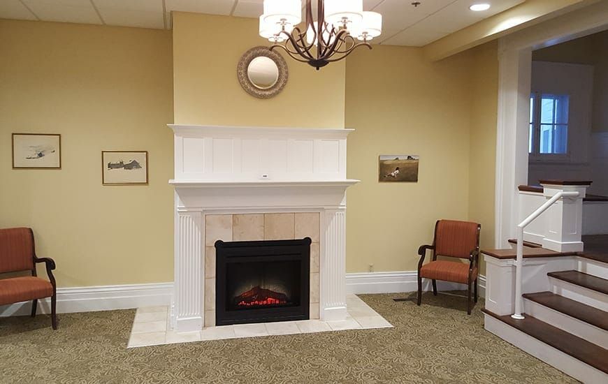 A cozy living room with a white fireplace and elegant decor.