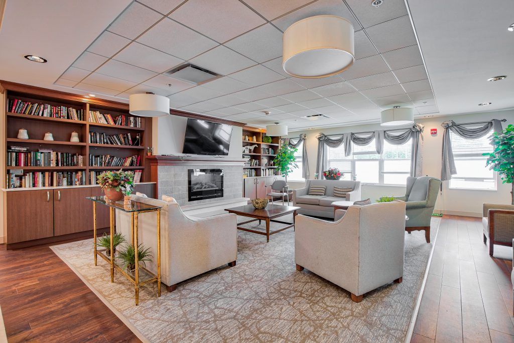 A modern living room featuring comfortable seating, a fireplace, and well-organized bookshelves.