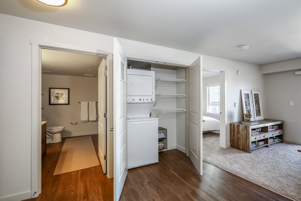 Modern apartment interior featuring a bathroom, laundry area, and bedroom.