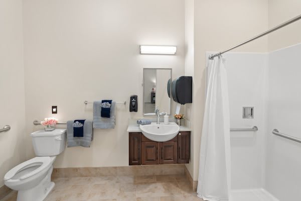 A clean and organized bathroom with a sink, mirror, and shower area.