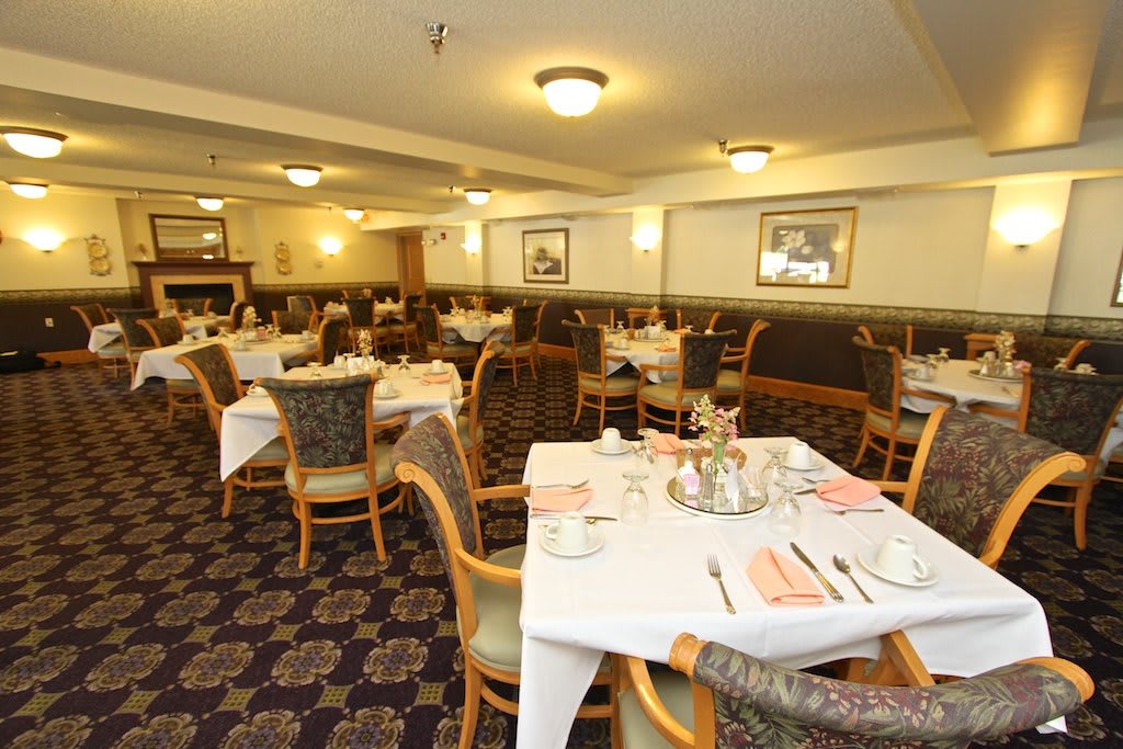 An empty restaurant dining area with neatly arranged tables and chairs.