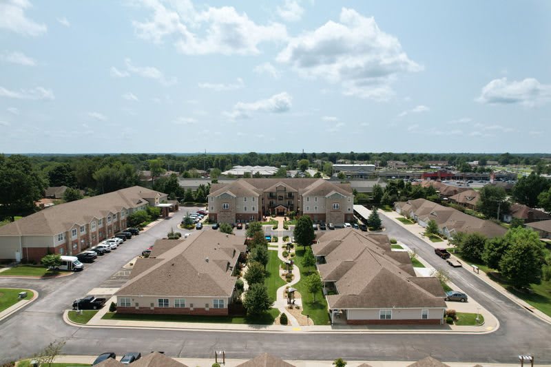 An aerial view of a residential complex with neatly arranged buildings and landscaped pathways.