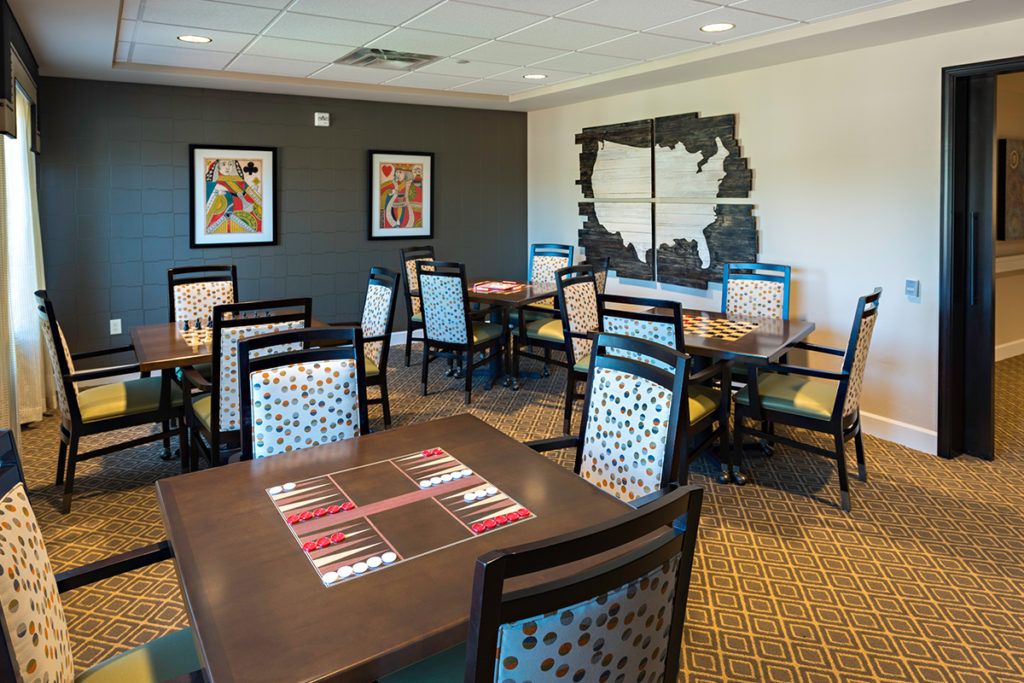 A modern dining area featuring elegantly arranged tables and chairs, with decorative artwork on the walls.
