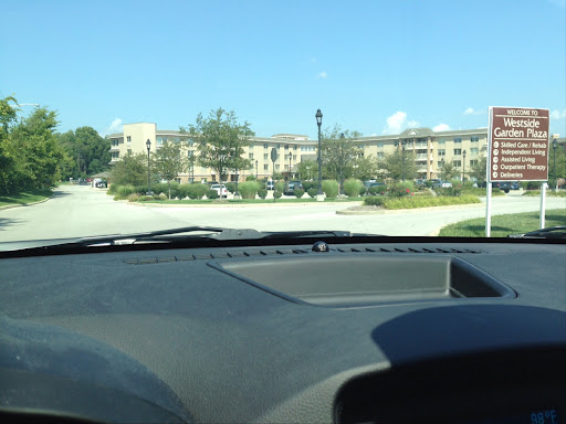 A view from inside a car, looking towards a building with a clear blue sky.