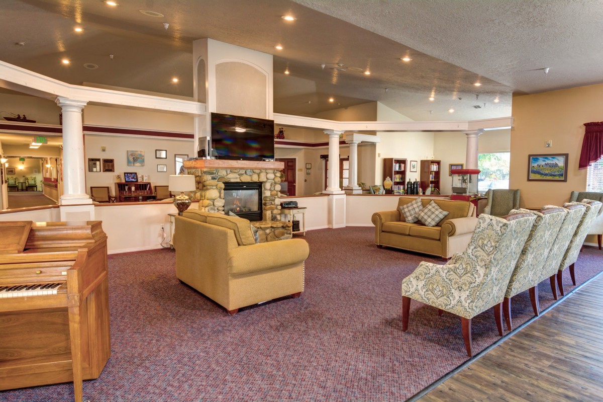 A spacious lobby area featuring comfortable seating, a fireplace, and a television.