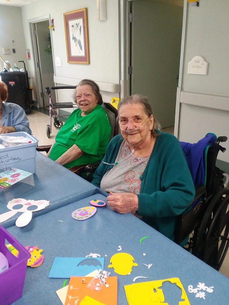 Elderly individuals enjoying a crafting activity together.