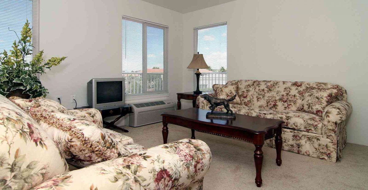 A cozy living room with floral upholstered furniture and a wooden coffee table.