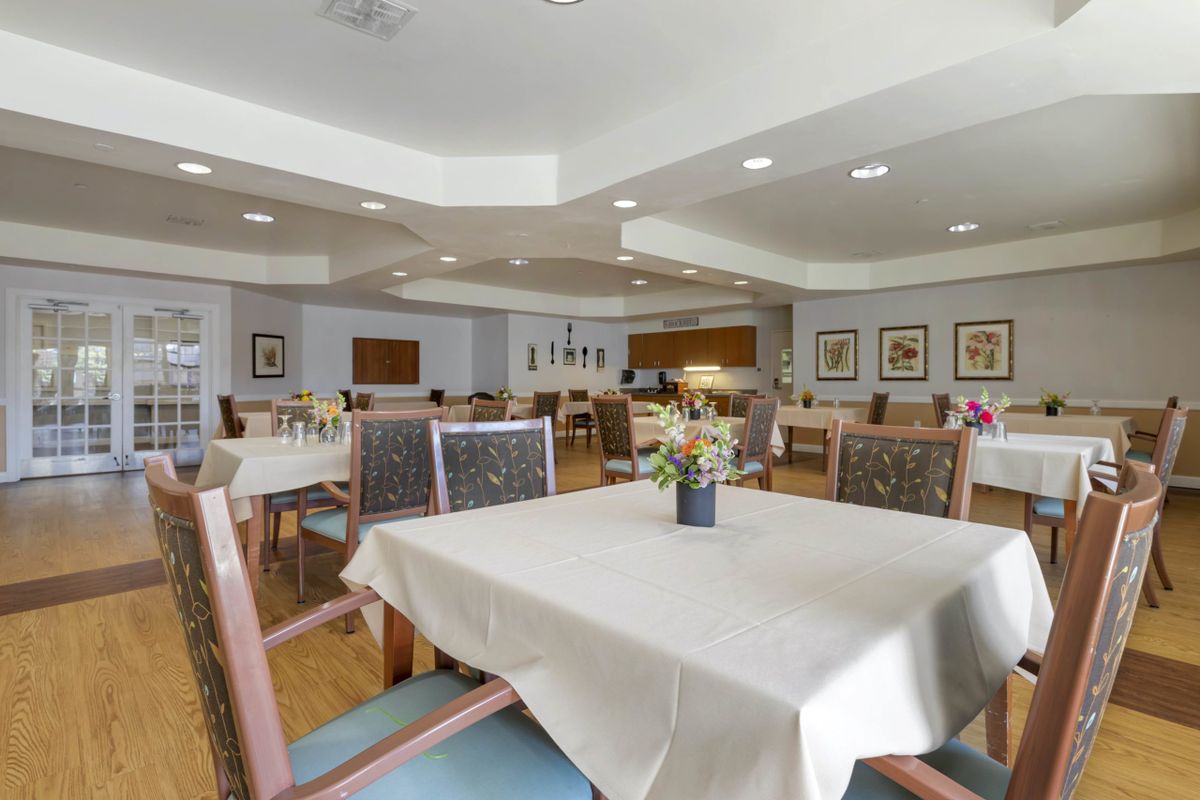 A spacious and well-lit dining area with neatly arranged tables and chairs.