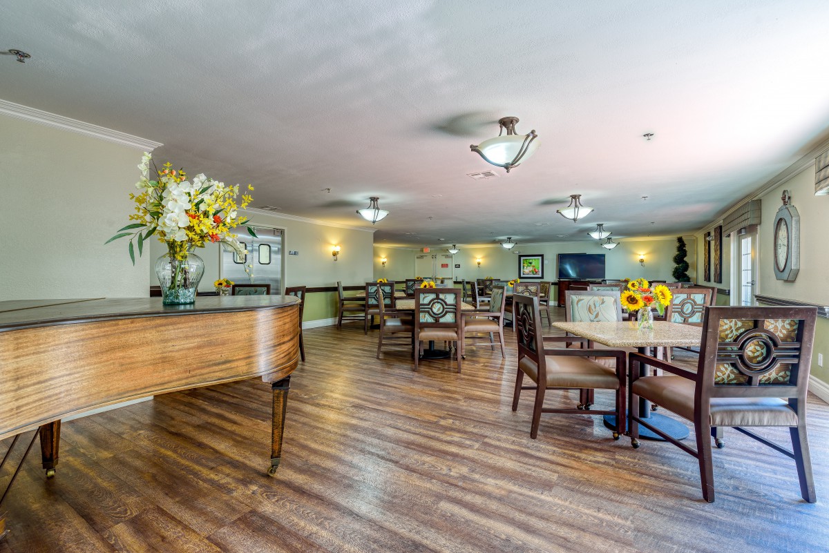A spacious dining area with wooden flooring and elegant decor.