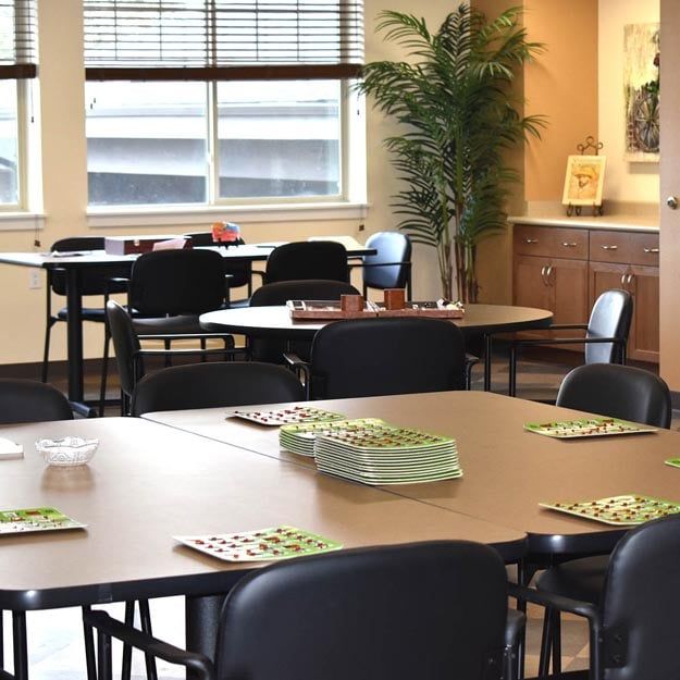 An empty classroom with neatly arranged tables and chairs.