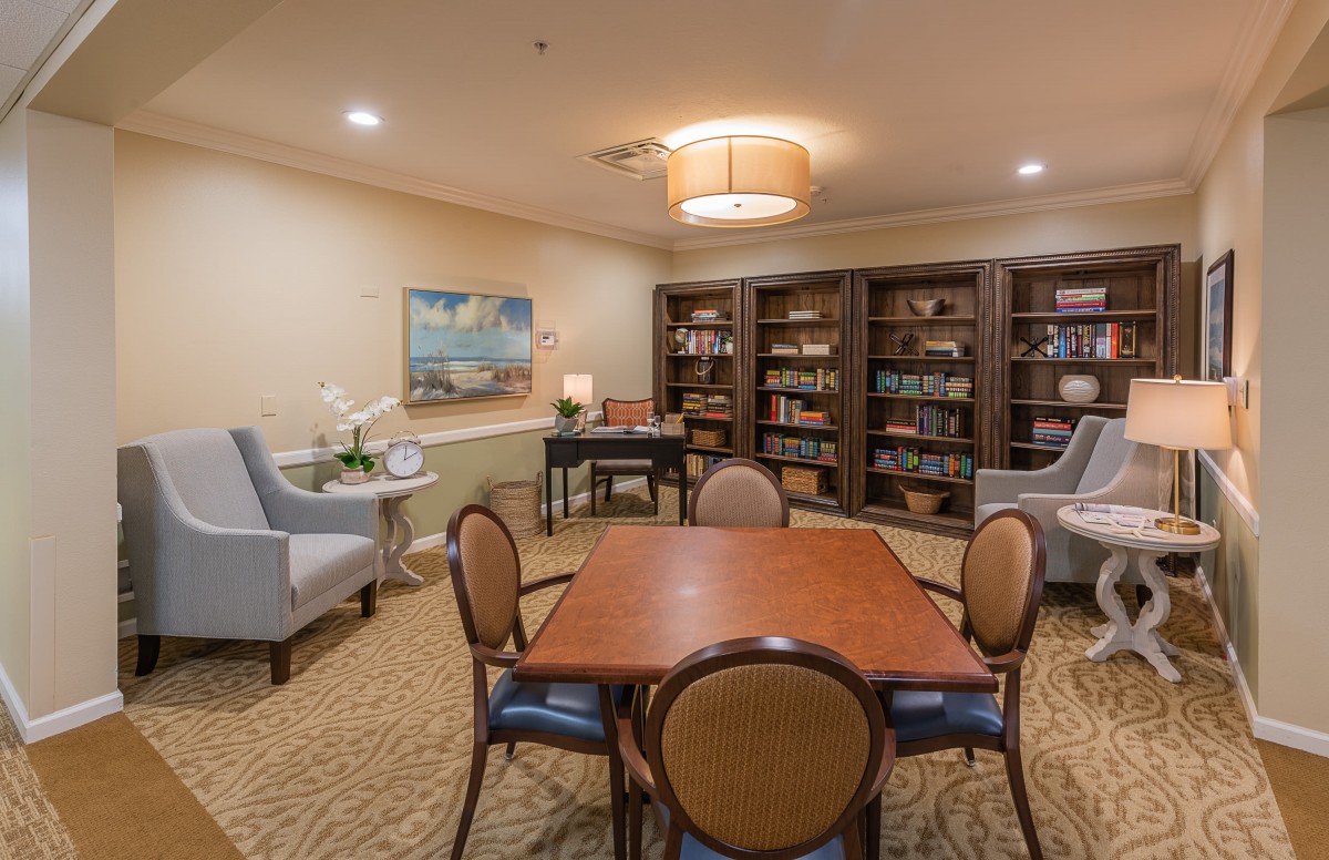 Cozy reading room with bookshelves and a central table for study or leisure.