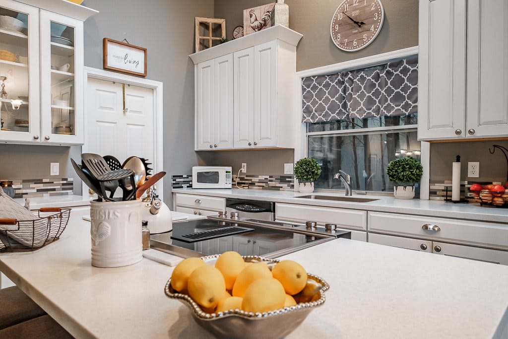 A cozy kitchen interior with a bowl of lemons on the countertop.