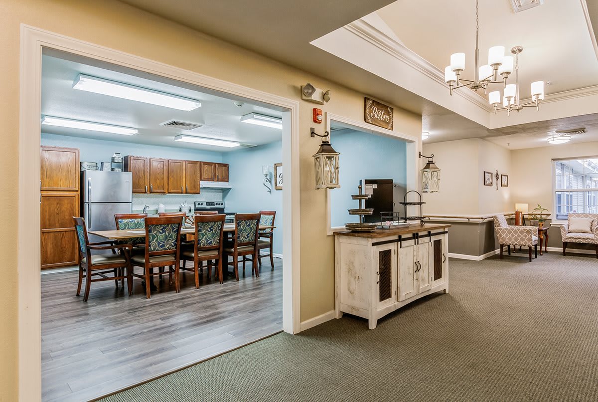 A view of a kitchen and dining area featuring wooden furniture and stylish lighting.