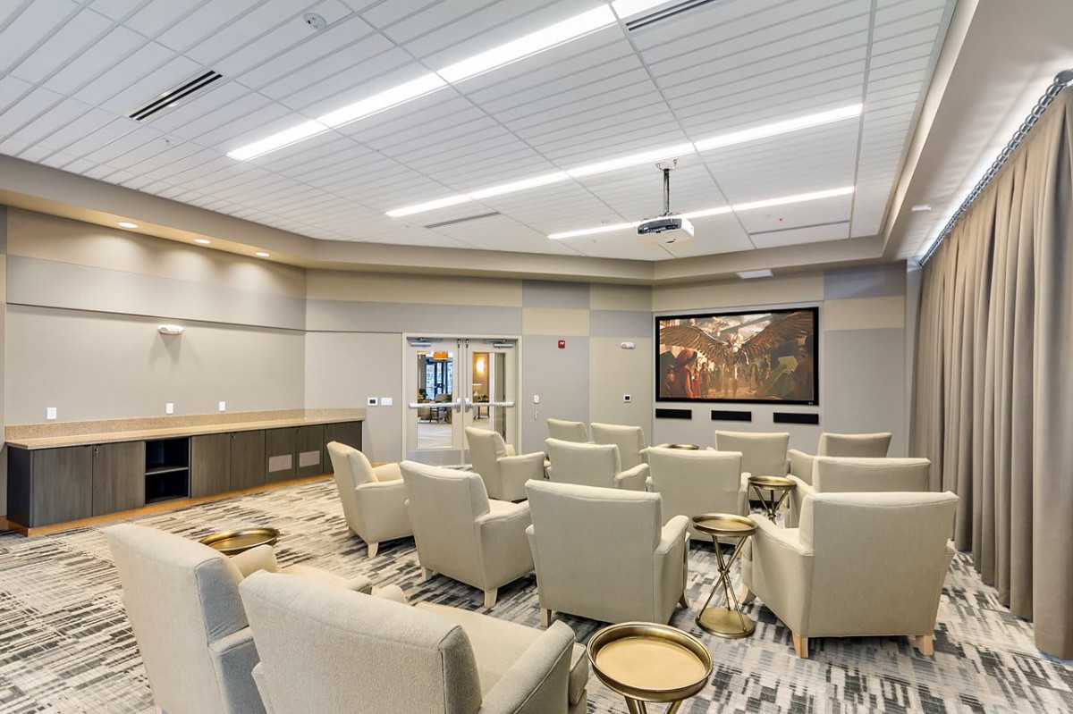 A modern home theater room with plush seating and a large screen.