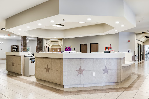 A modern hotel reception area featuring a stylish front desk and ambient lighting.