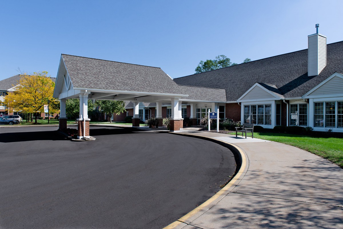A residential building with a covered entrance and driveway.