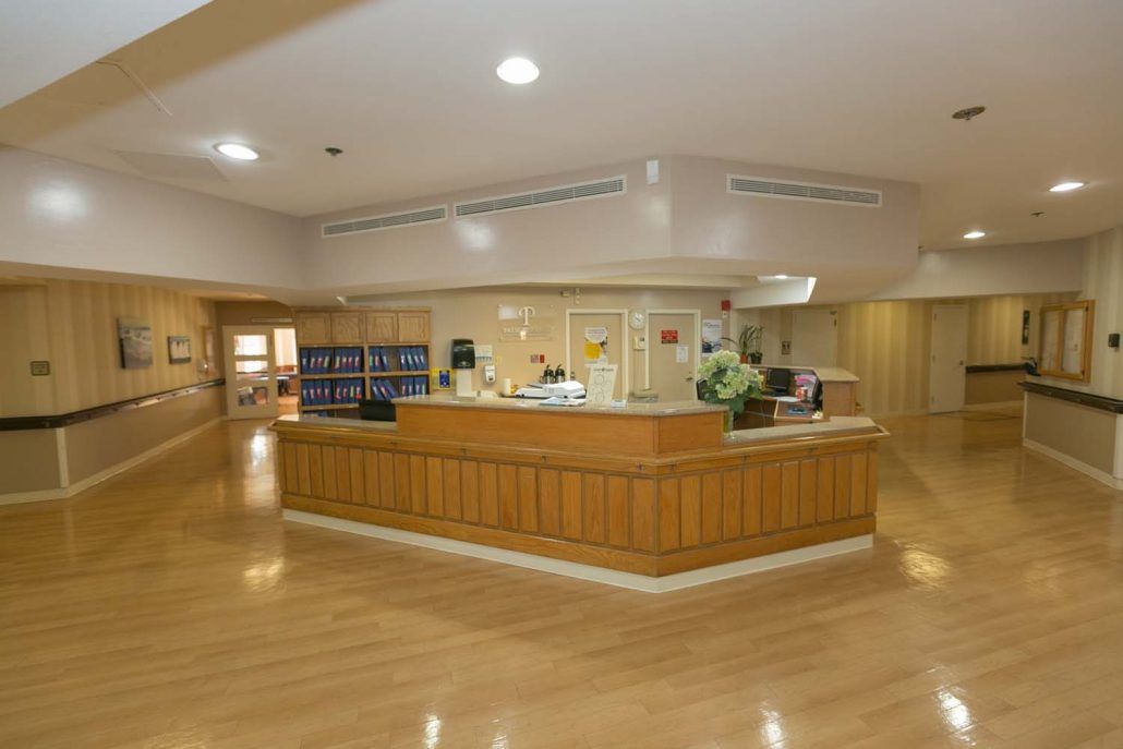 A well-lit hospital reception area with a central desk and clean surroundings.