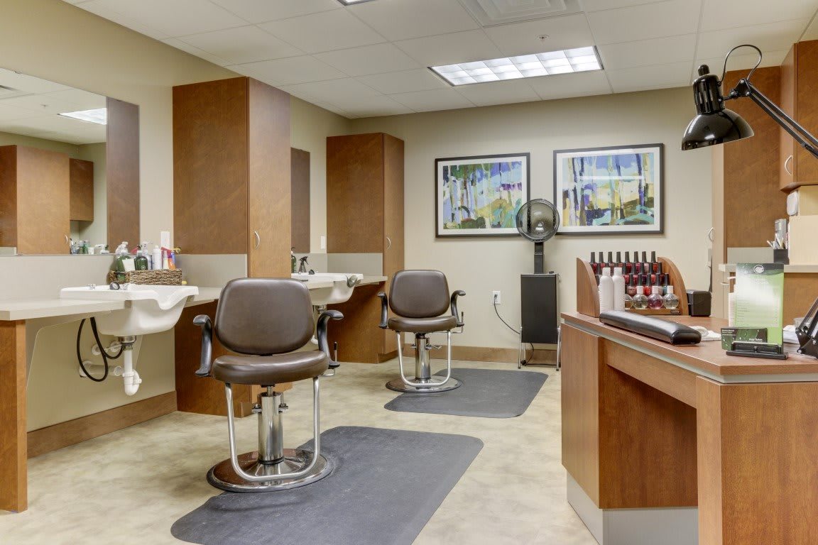 A modern and neatly organized barbershop interior with chairs, mirrors, and hairdressing equipment.