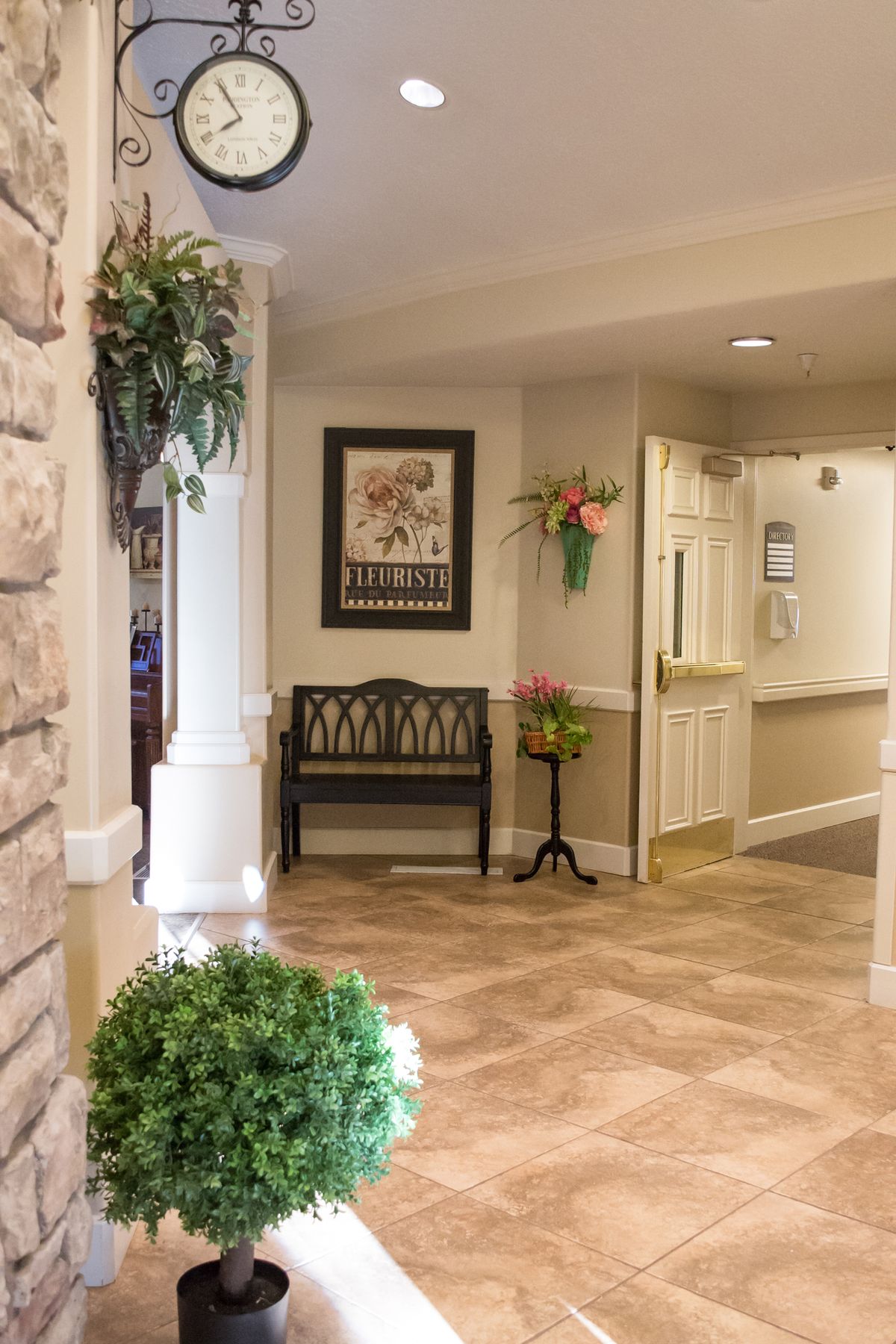 A welcoming lobby area featuring a bench, decorative plants, and artwork on the wall.