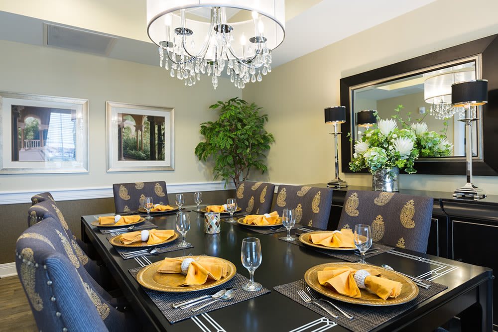 A beautifully set dining room table with a chandelier and elegant decor.