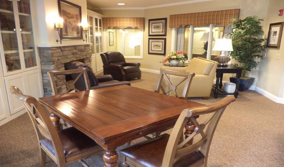 A cozy living room with a wooden table, comfortable armchairs, and a fireplace.