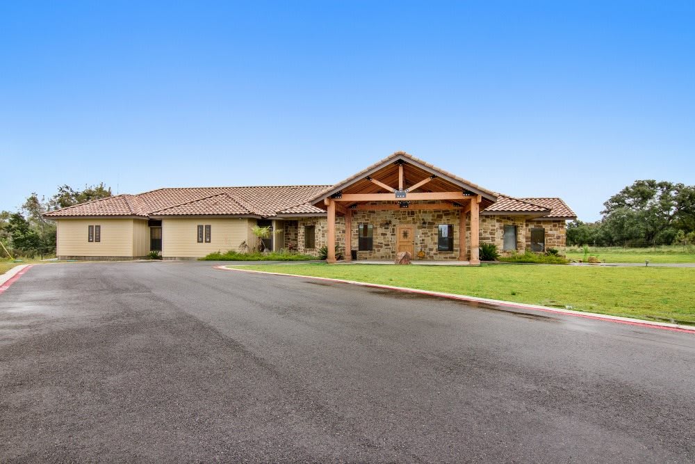 A single-story residential building with a well-maintained lawn and driveway.