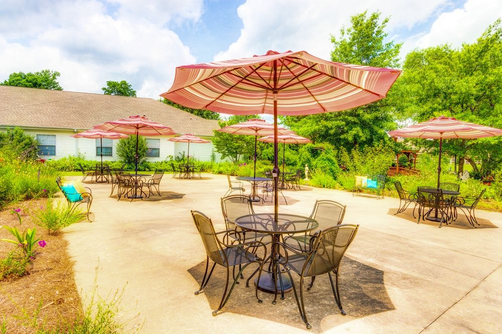 A sunny patio area with tables and chairs under umbrellas.