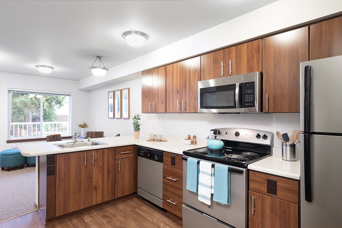 A modern kitchen with wood cabinets and stainless steel appliances.