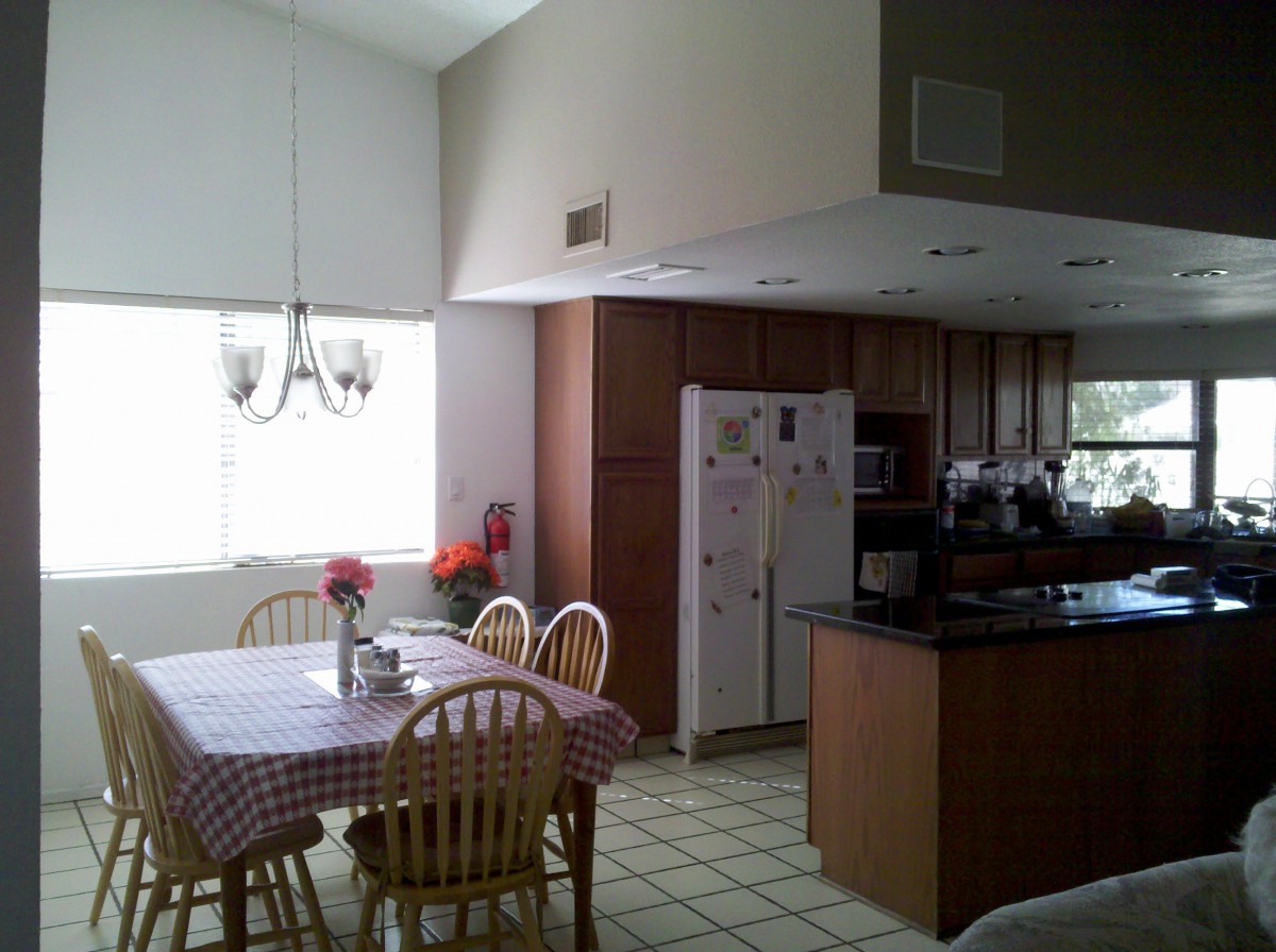 A well-lit kitchen and dining area with wooden cabinets and a table set for dining.