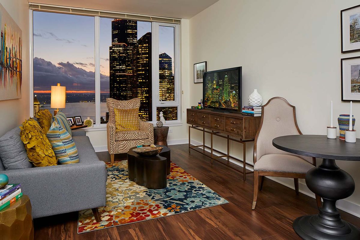 A cozy living room in an apartment with a stunning city view during evening.