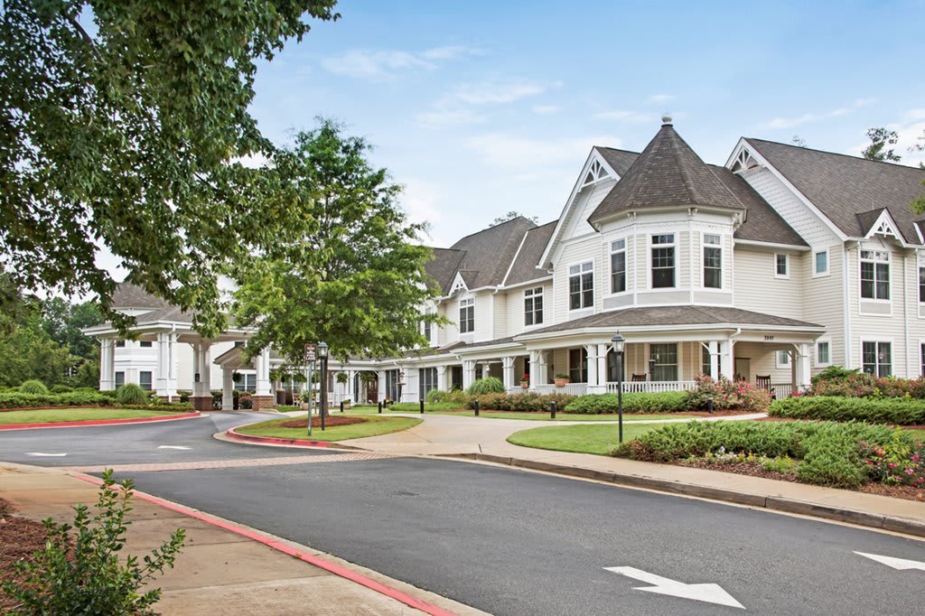 A picturesque suburban neighborhood with white houses lined along a tree-shaded street.