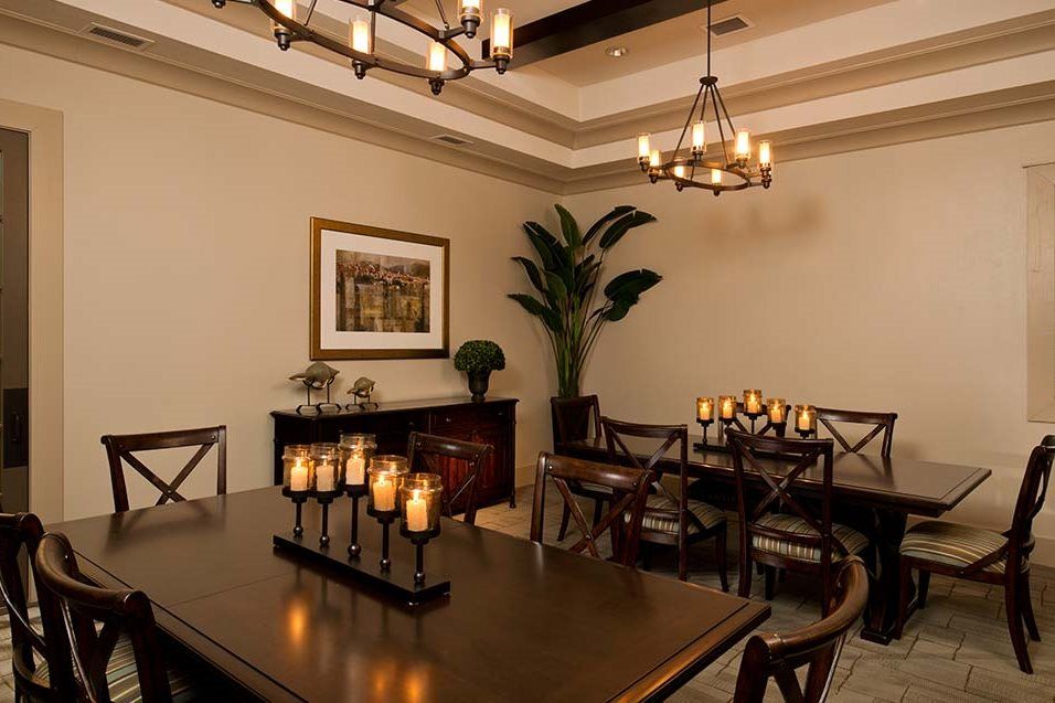 Elegant dining room with candles and chandeliers creating a warm ambiance.