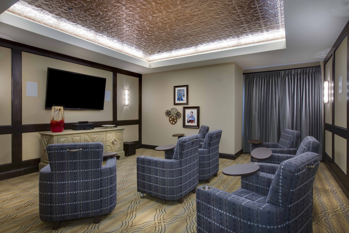 A modern lounge area with comfortable armchairs and a large television, ideal for meetings or relaxation.