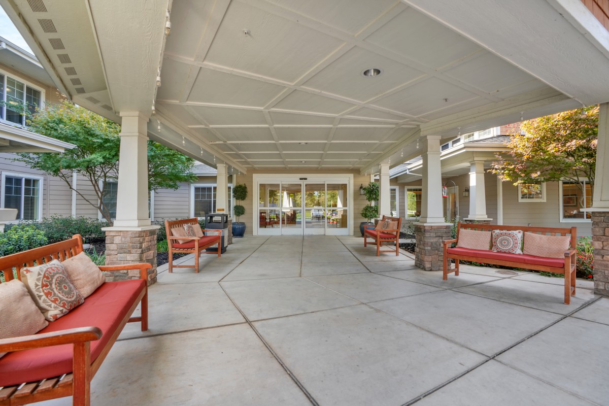 A spacious outdoor patio with comfortable seating and a covered walkway.