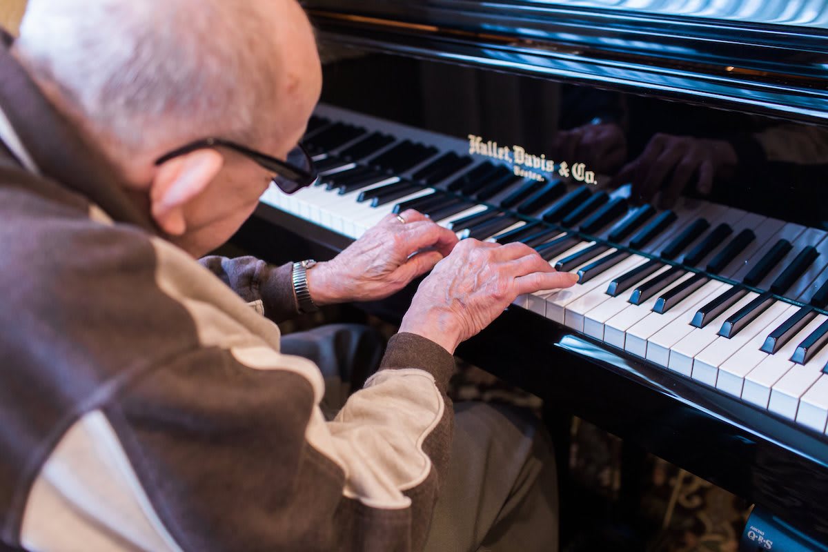An elderly person playing the piano.