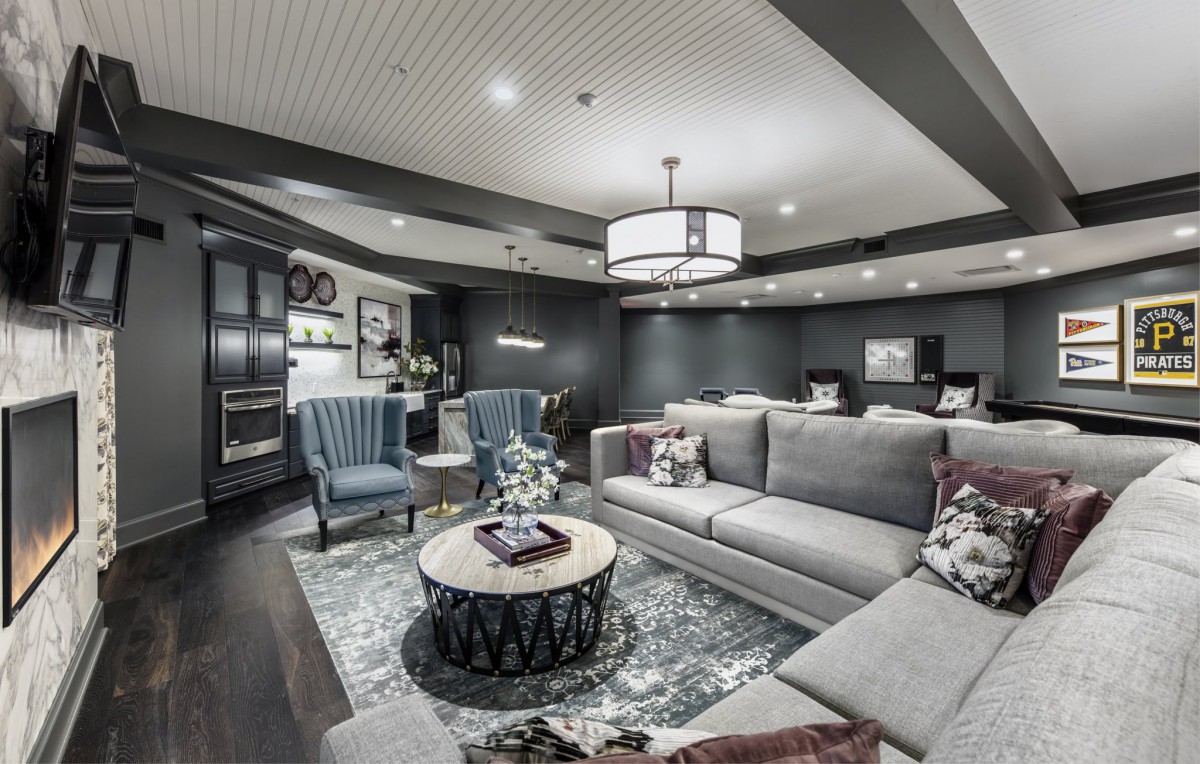 A modern living room with a cozy gray color scheme, featuring comfortable seating and elegant lighting.