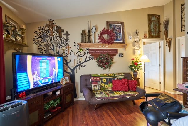 A cozy living room with vibrant decor and a TV turned on.