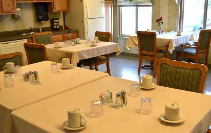 A neatly arranged dining room with tables set for a meal.