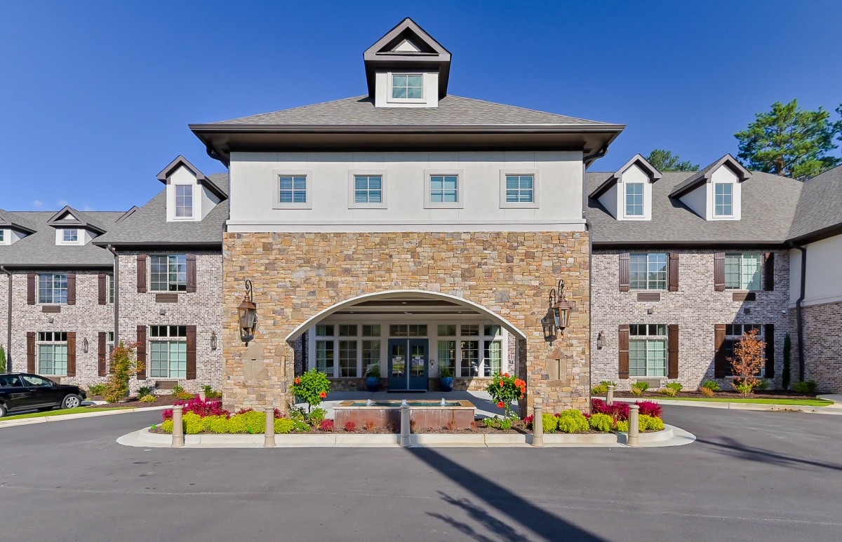 A stone facade building with large entrance and well-maintained landscaping.