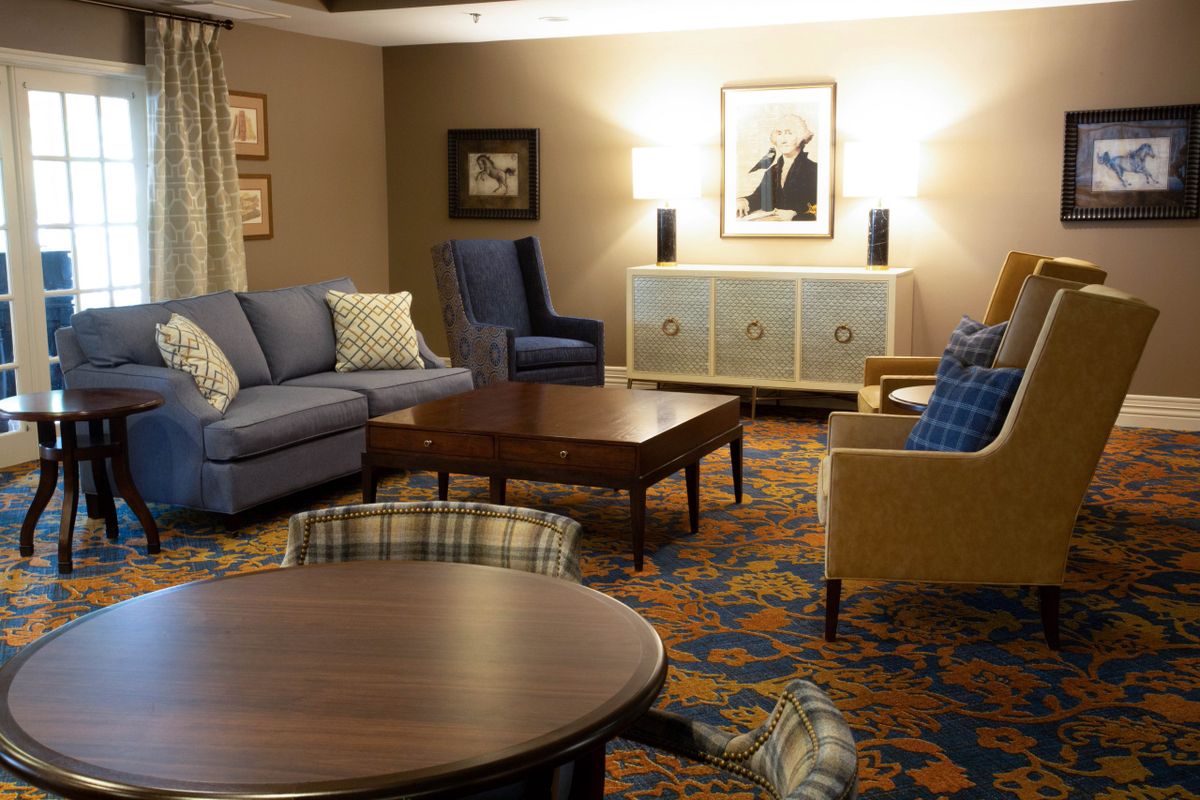 A cozy living room with various seating options and warm decor.