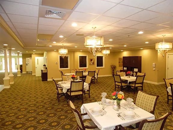 A cozy dining room with elegantly set tables and warm lighting.