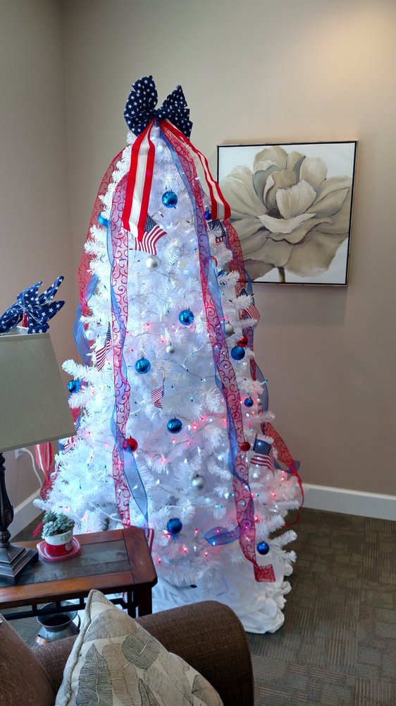 A white Christmas tree decorated with a patriotic theme, featuring red, white, and blue colors.