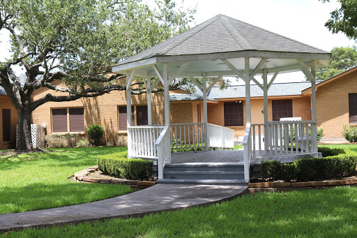 A charming white gazebo surrounded by well-maintained greenery, offering a peaceful outdoor space.
