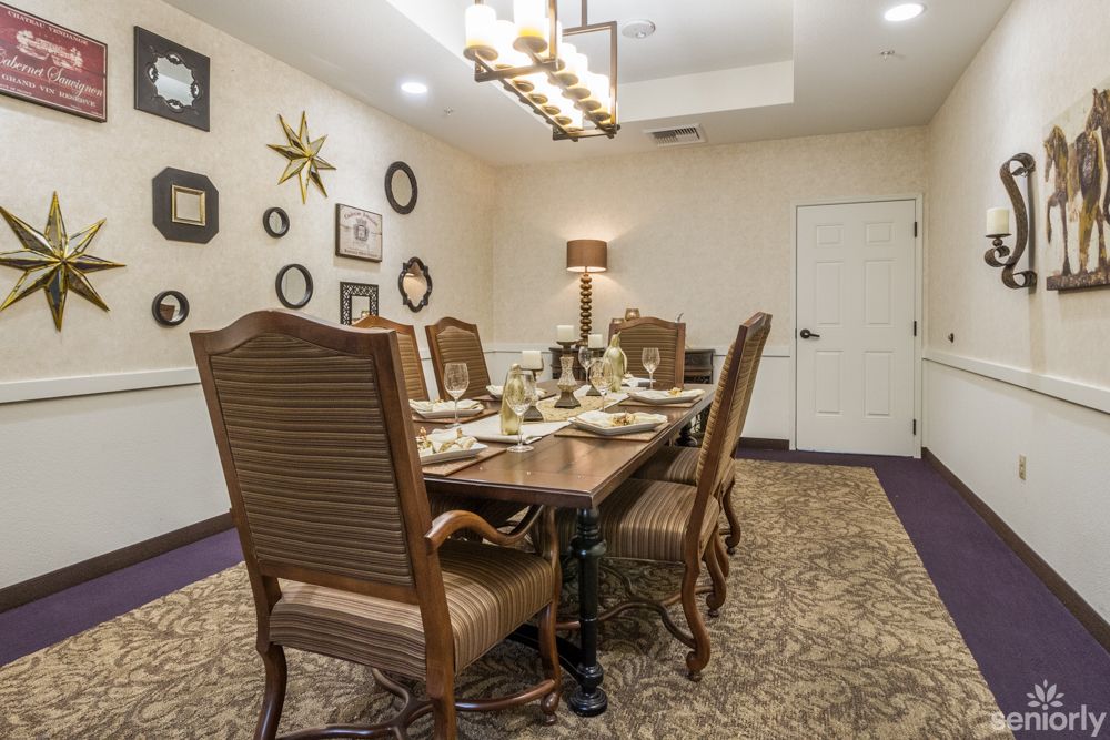 A beautifully decorated dining room with an elegant table setting and stylish wall decor.