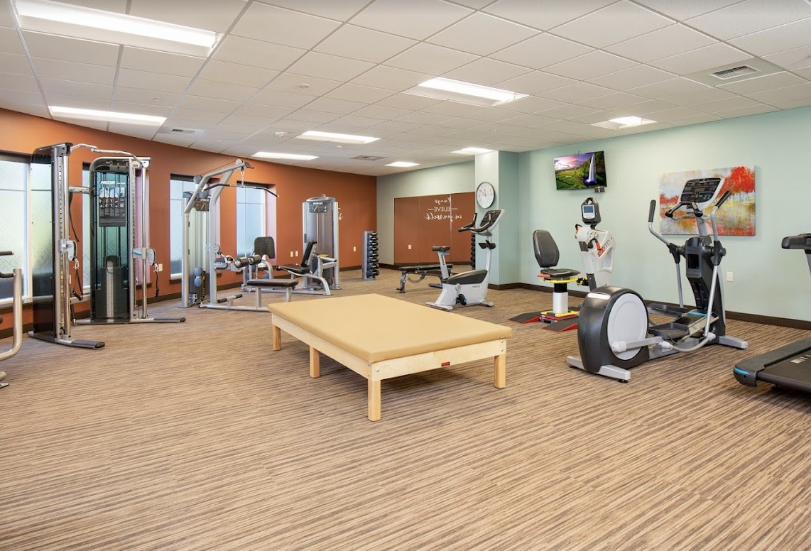 A modern indoor gym with various fitness equipment and exercise machines.