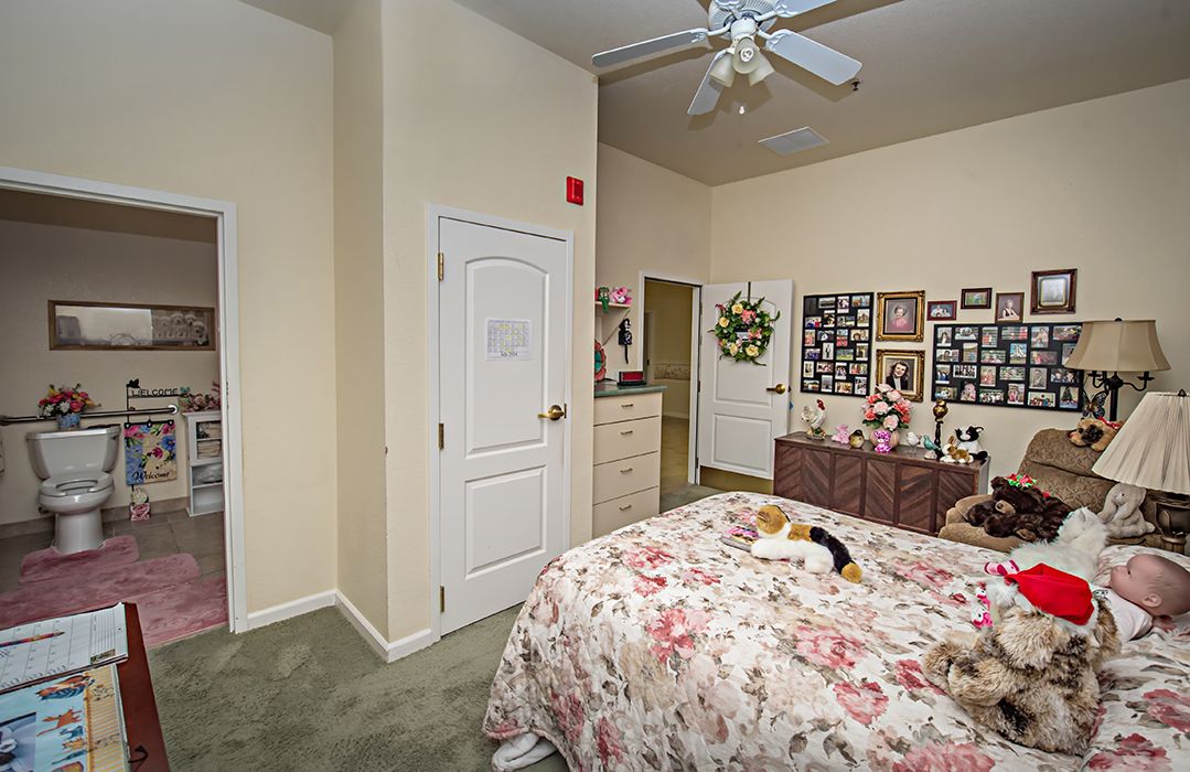 A cozy bedroom with floral bedding and personalized decorations.