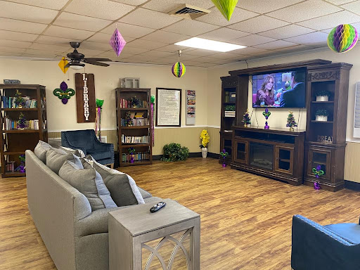A cozy living room setup featuring comfortable seating, decorative shelves, and a large television.