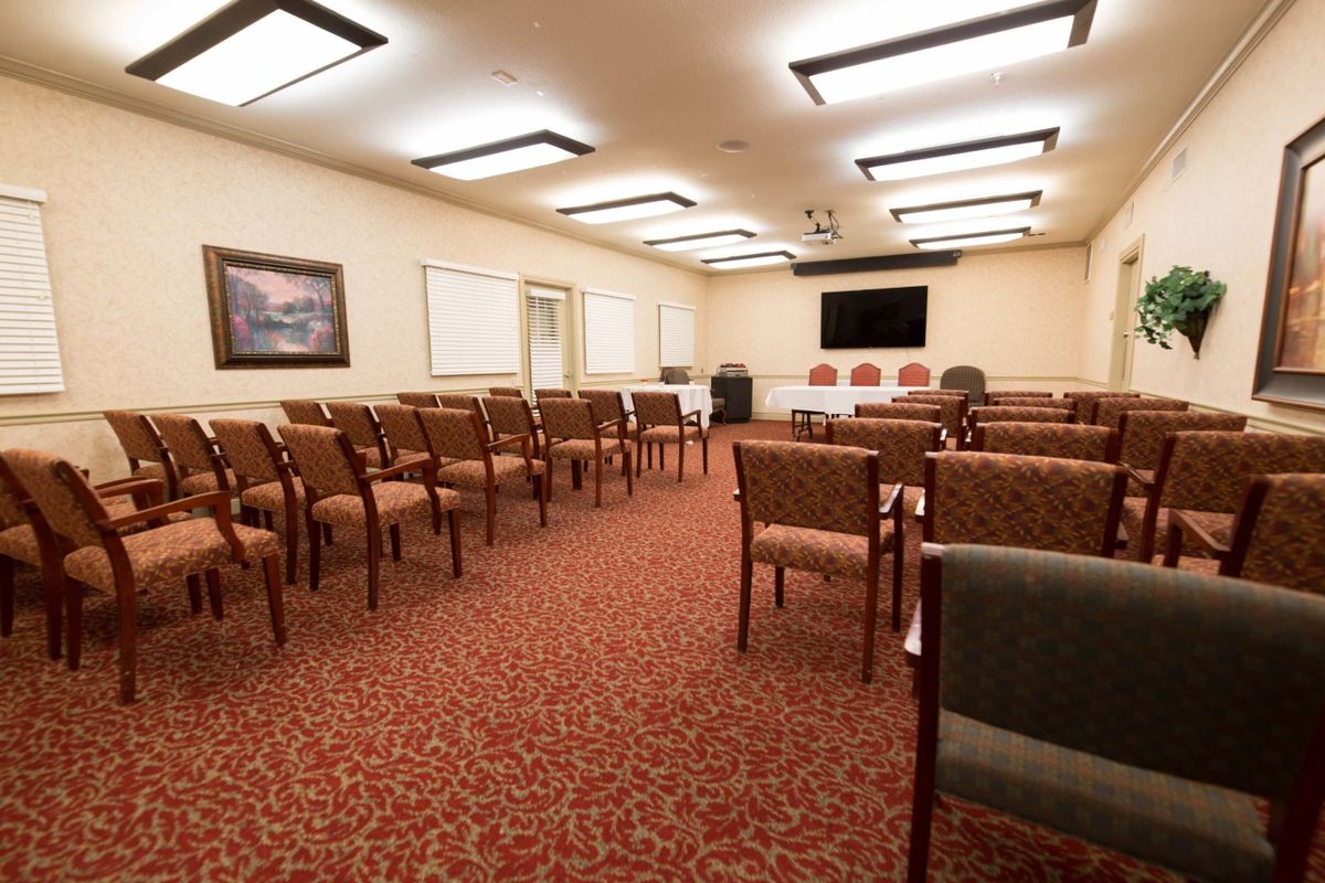 A well-organized conference room with rows of chairs facing a TV for presentations.