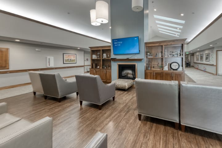 A modern lounge area featuring comfortable seating, a fireplace, and a mounted television.