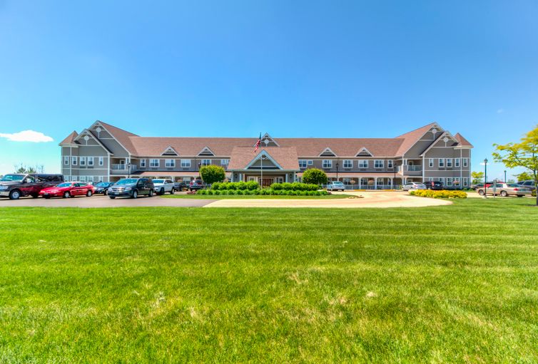 A picturesque hotel building with a grassy foreground and bright blue sky.